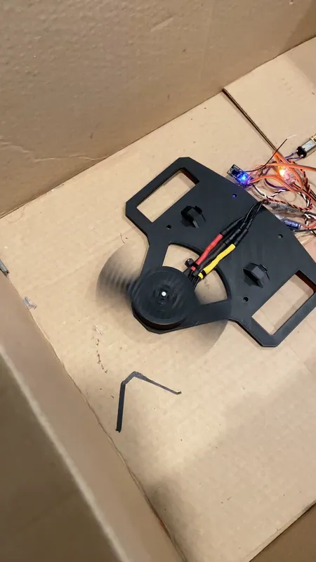 The spin test rig: plate, motor, blade and ESCs, in a cardboard box