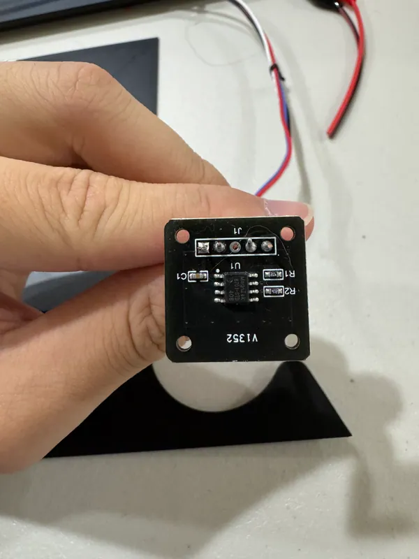 The sensor board up close: a hole in each corner and the chip in the middle