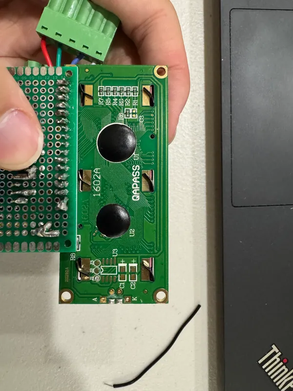 The perfboard soldered onto the back of the LCD, with the green pluggable terminal