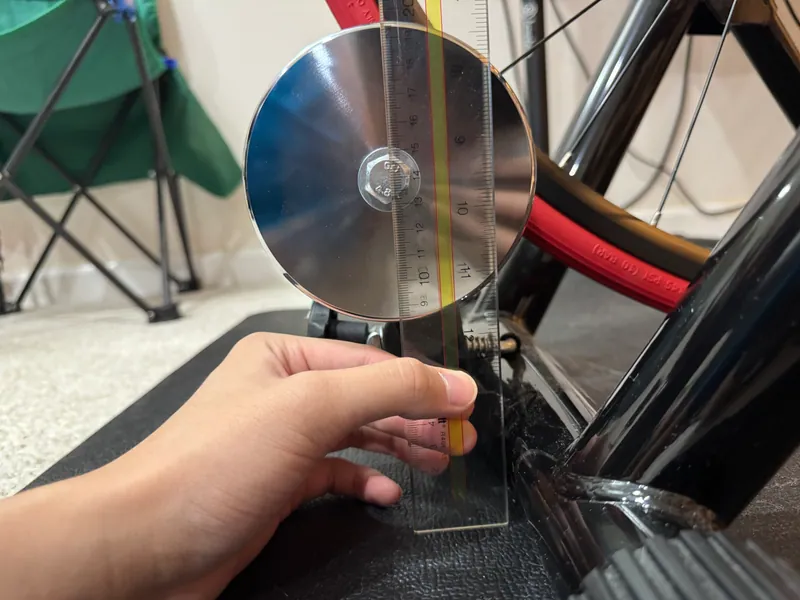 A ruler from the flywheel's axle down to the trainer frame