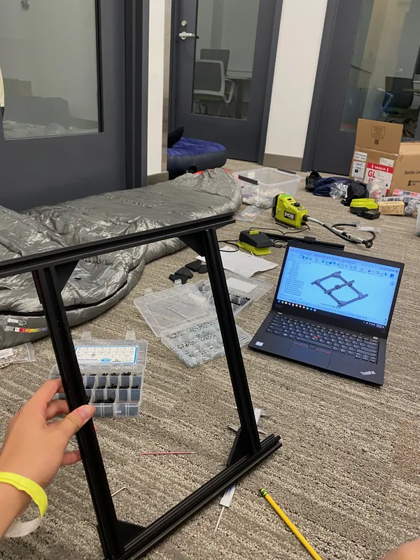 Three sides of the frame bolted up, with the gantry CAD on the laptop
