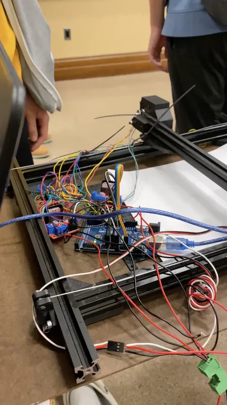 The electronics inside the frame: a microcontroller board, red driver boards and a nest of jumper wires