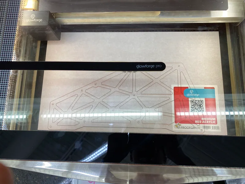 Aug 1: a truss sideplate cut from red acrylic on the laser cutter bed