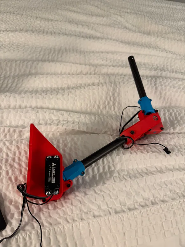 The assembled arm: the red shoulder wedge and servo, a carbon link, the elbow and the second link