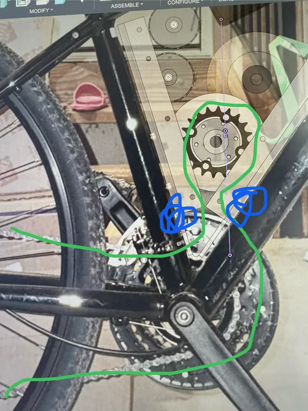 The chain routing, sketched over a photo of the drivetrain: the chain wraps the drive sprocket, with two jockey wheels