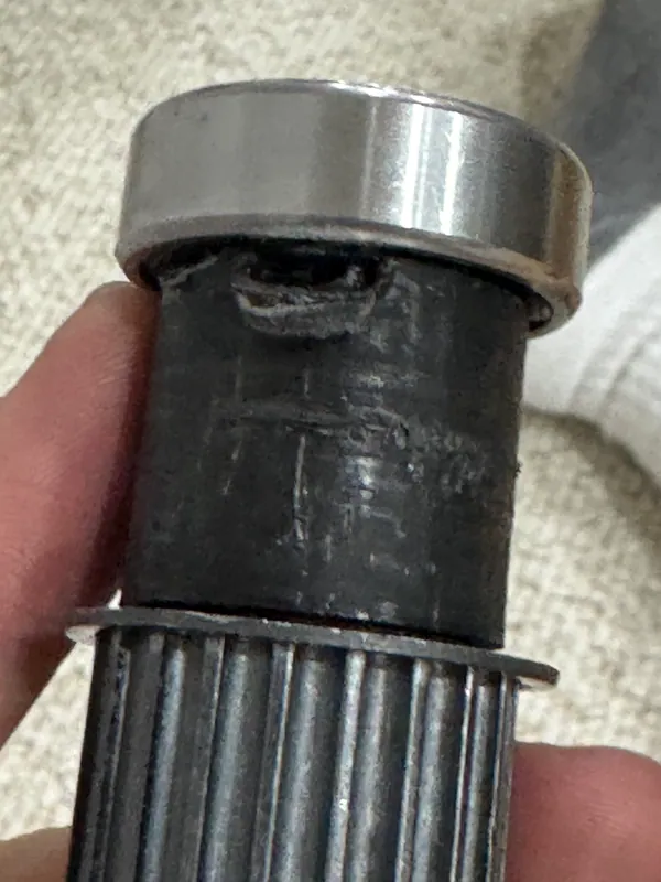 A chewed-up printed spacer between a 6202 bearing and the 20T pulley