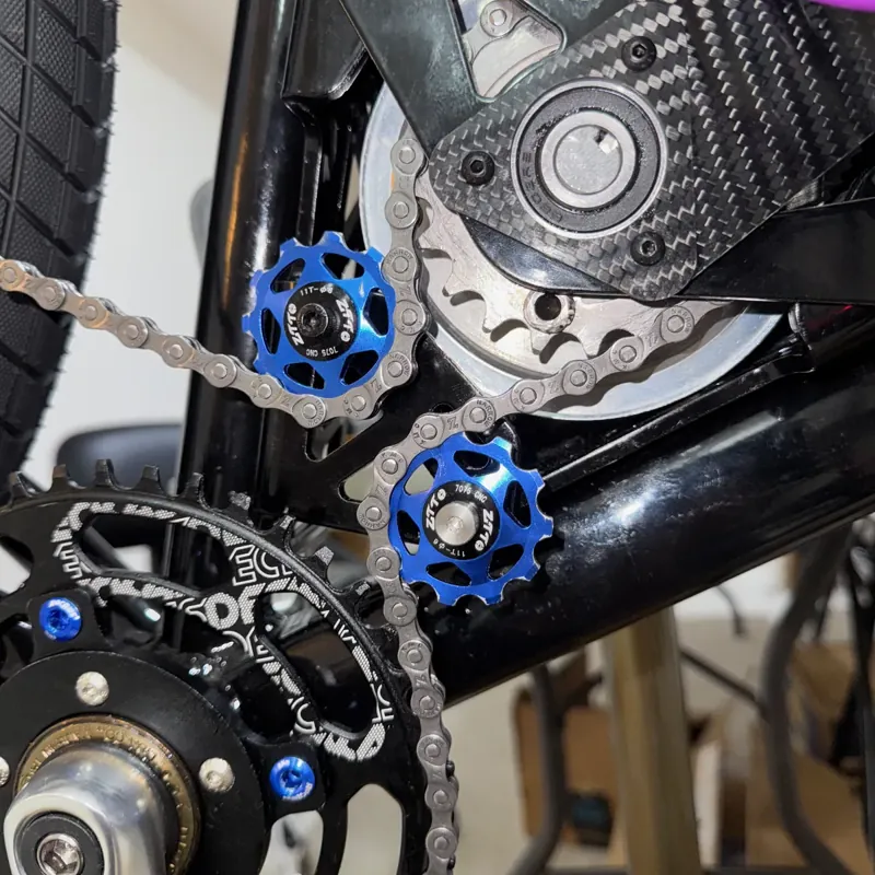 V1: the chain comes in under the upper jockey, wraps the drive sprocket and leaves past the lower jockey