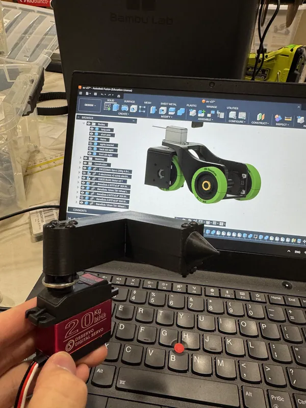 The servo in hand, the front module’s CAD behind it