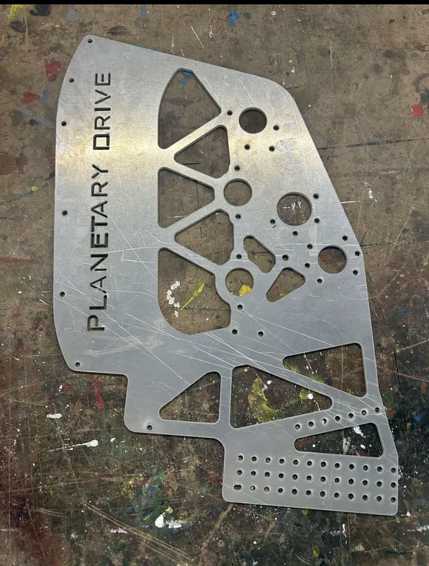 Feb 13: a shooter side plate waterjet cut from my DXF, with the triangle pockets and PLANETARY DRIVE cut through