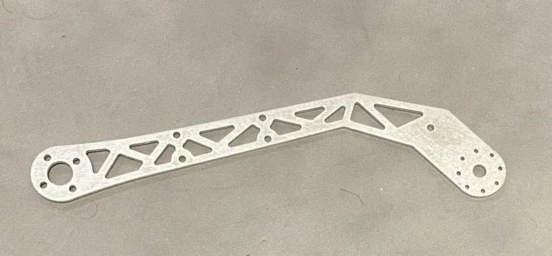 The arm link as cut, with triangular truss cutouts