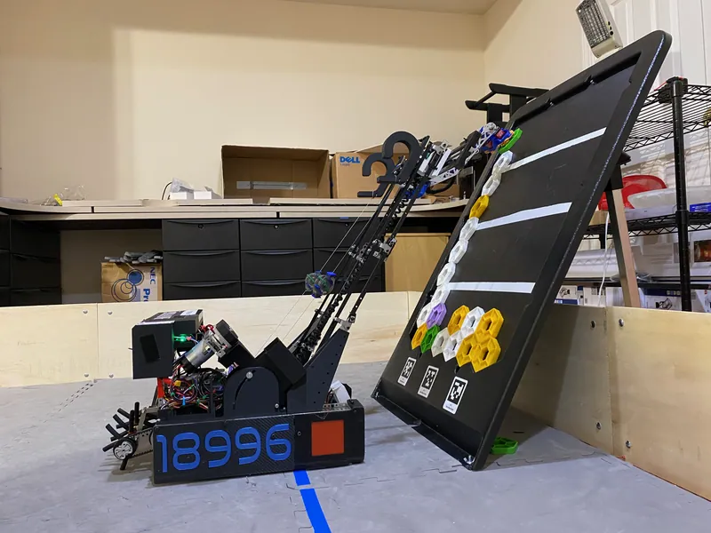 Feb 17, 2024: the finished robot at a backdrop, lift and arm up, the flap intake at the front