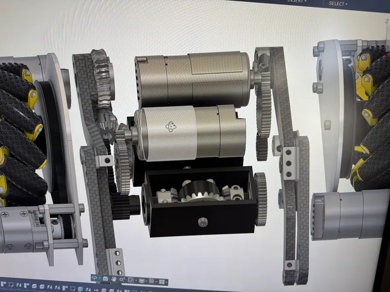 The intake gearbox in the CAD, March 20, 2026: the two intake motors stacked over a differential housing with its bevel gears showing, between carbon fiber plates and the mecanum wheels