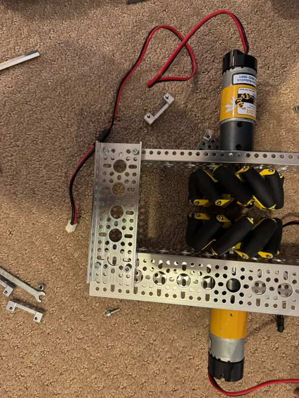 The one part we built: the drivetrain test chassis going together on February 28, 2026, a pair of mecanum wheels in the middle of the frame and a motor on each end
