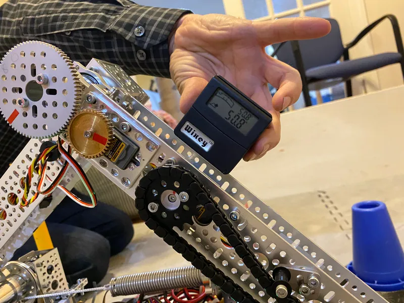 Feb 7, 2023, on the arm: a brass gear on a servo meshing with a large aluminum gear, next to a chain sprocket