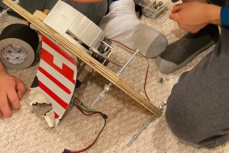The shooter plate from the side, before it went on the robot: the white cup, the threaded rods and a servo on its bracket