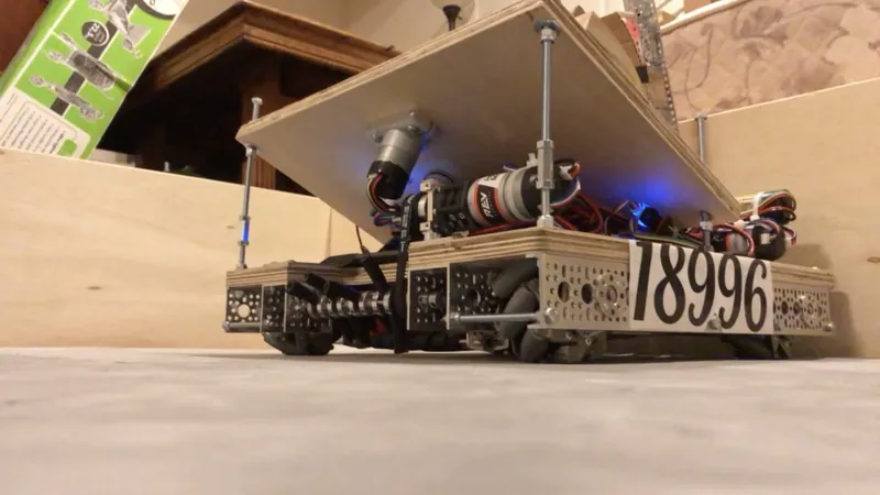 From the floor: the tilted plate on its threaded rods, the motors under it, and the drive base