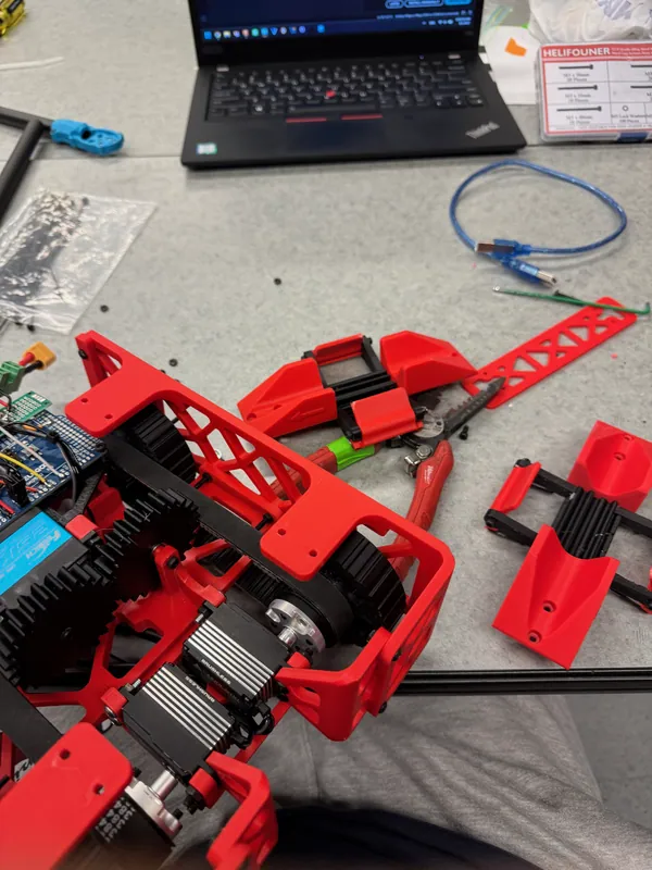 Latch assemblies, black arms and red doors, laid out next to the rover, Aug 1