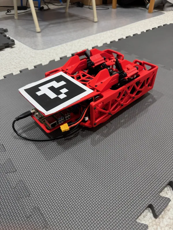 The finished rover: the two latches on its deck, doors closed, behind the AprilTag