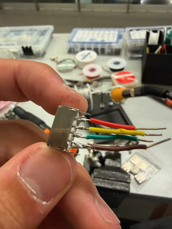 A connector with four leads soldered and heat-shrunk; every wire in the chain runs inside the modules