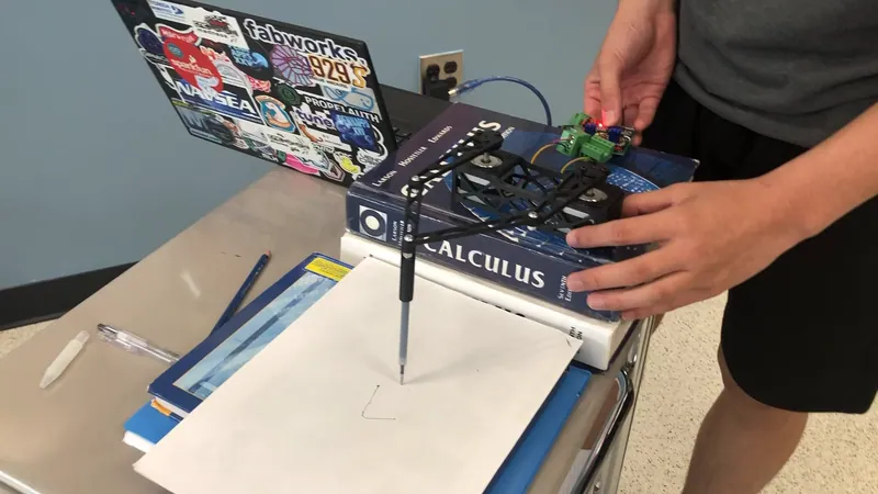 The setup: the plotter on a stack of books, the paper in front of it